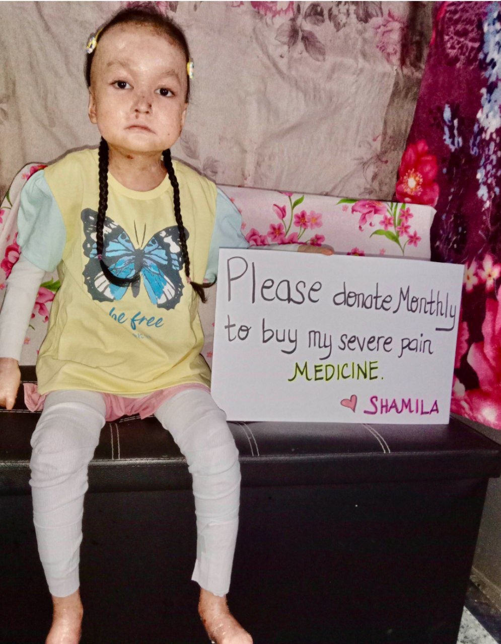 Shamila holding sign Please donate for my pain medicine